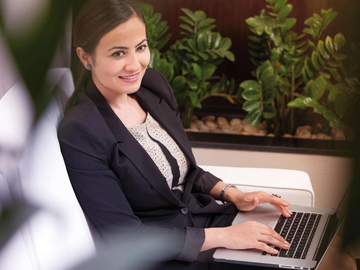 Movenpick Jumeirah Village Triangle Dubaj Zewnętrze zdjęcie A business woman working on a laptop